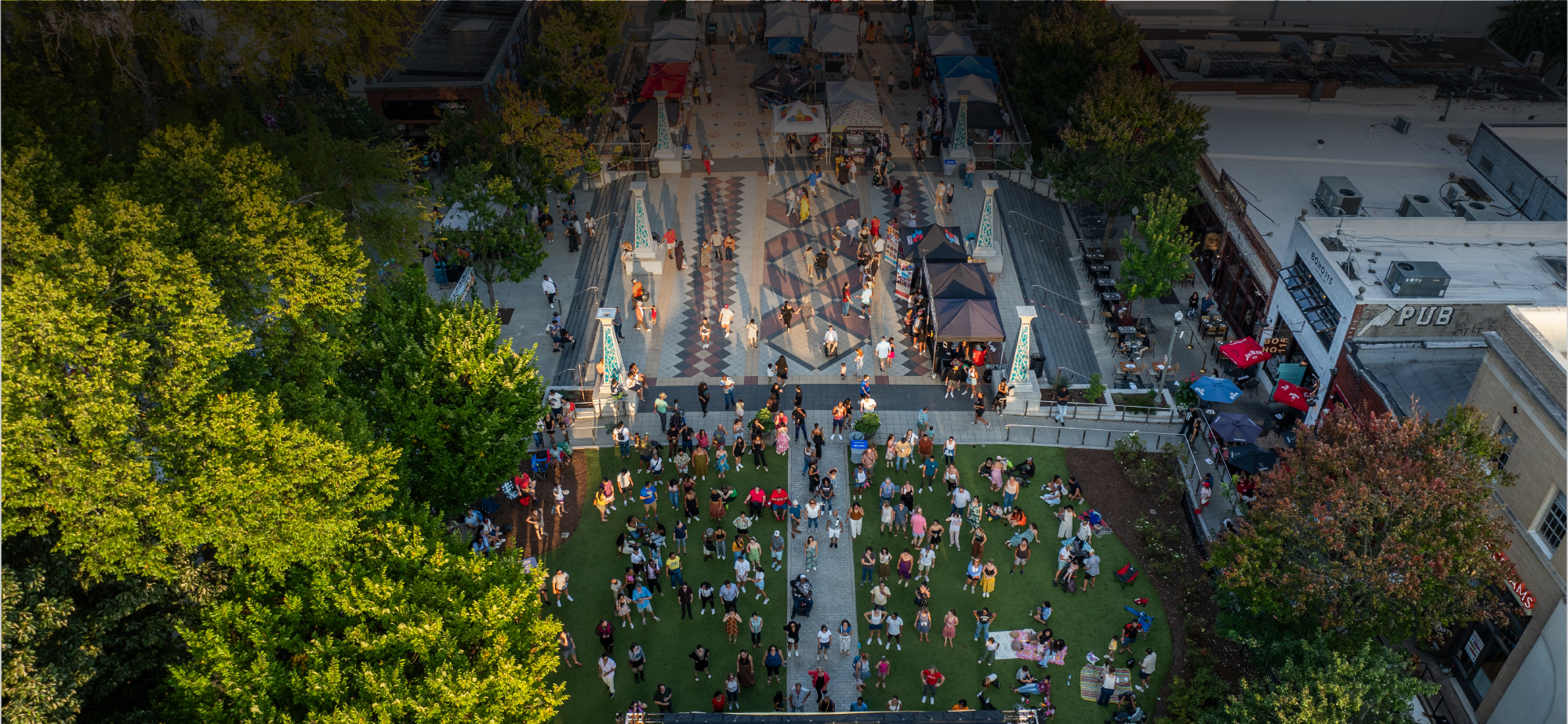 Drone shot of the Downtown Decatur Square filled with people and tents and surrounded by businesses