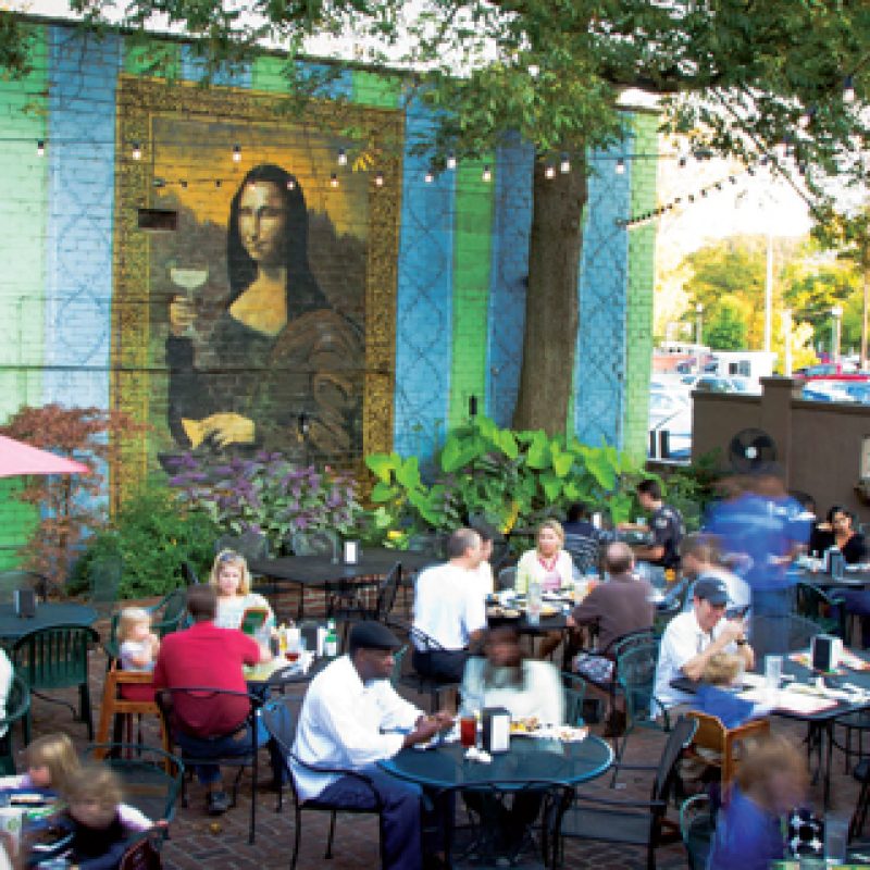 Patio of Raging Burrito showing Mona Lisa with A Margarita mural in Decatur, GA