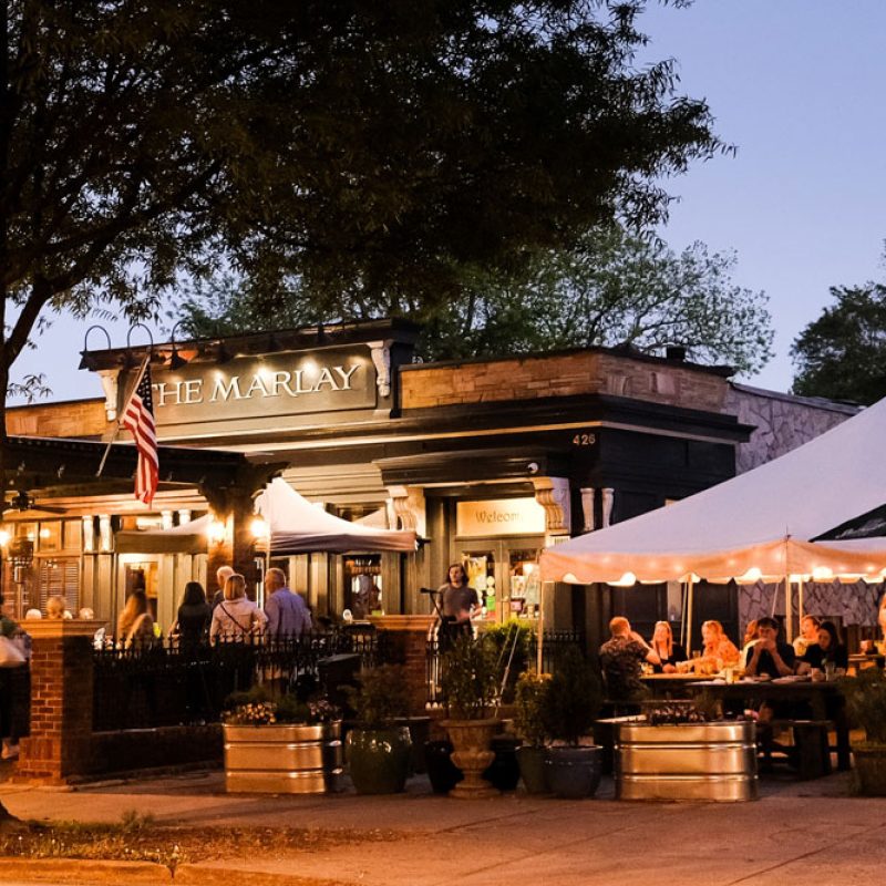 Exterior image of the Marlay House in Decatur, GA with people eating outside.